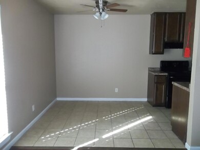 Kitchen featuring electric range, light tile patterned floors, and ceiling fan