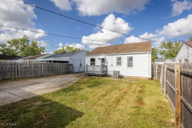 Back of house with a patio area, a lawn, and cooling unit