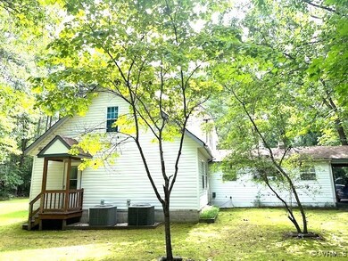 Back of house featuring a lawn and central AC unit