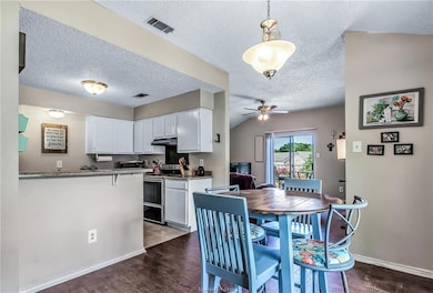Dining area with visible vents, baseboards, dark w