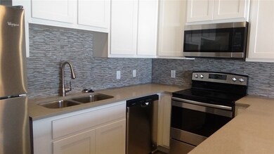 Kitchen with stainless steel appliances, sink, whi