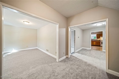 Spare room featuring a textured ceiling and light colored carpet