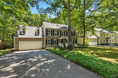 Colonial house featuring a garage and a front lawn