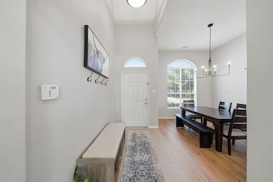 Another view of the entryway and formal dining room with beautiful floors and arched windows that look at to the front yard.