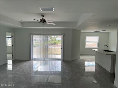 Spare room featuring a raised ceiling, ceiling fan