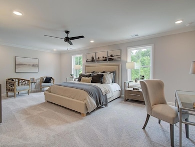 Bedroom with ornamental molding, light colored carpet, ceiling fan, and recessed lighting