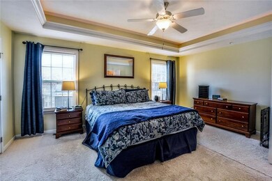 The first floor master bedroom boasts a tray ceili