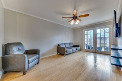 Living room featuring light hardwood / wood-style floors, crown molding, and ceiling fan