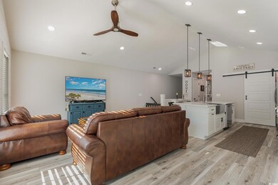 Living room with vaulted ceiling, sink, light wood
