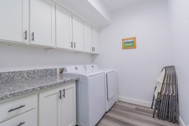 Laundry area featuring light wood-style flooring, cabinet space, and washer and dryer
