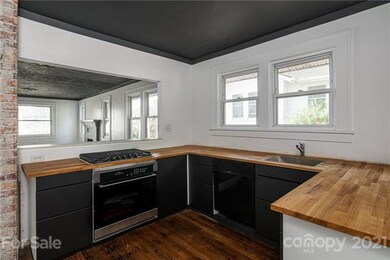 Brand new modern kitchen with new gas range, electric oven and butcher block countertops