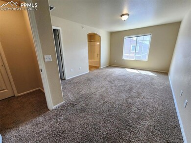 Unfurnished bedroom featuring arched walkways, carpet floors, ensuite bath, and baseboards