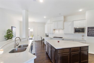 This kitchen is by far any chef’s dream! This spacious kitchen features white stained wood cabinets, quartz countertops, SS appliances, modern tile backsplash, recessed lighting, extended counter space, large kitchen island, and a walk-in pantry all overlooking your huge family room.