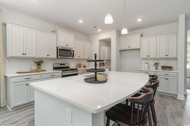 Kitchen featuring white cabinets, stainless steel 
