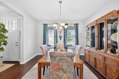 Dining area with plenty of natural light, dark wood finished floors, and a chandelier