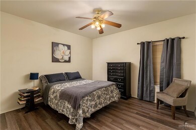 Bedroom with ceiling fan and dark wood-style floors