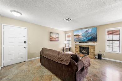 Living area featuring a brick fireplace and a textured ceiling