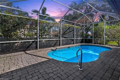 Pool at dusk featuring an outdoor pool, glass encl