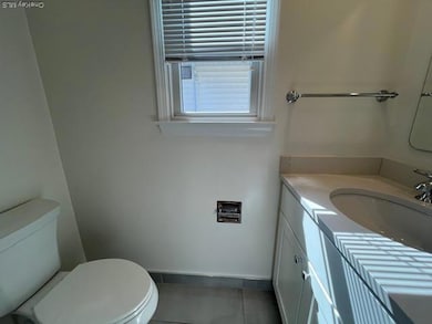 Bathroom with vanity and dark tile patterned flooring