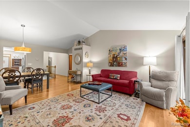 Living room with light wood finished floors and vaulted ceiling