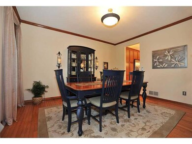 Dining Room. The spacious dining room is adorned with crown moulding and rich hardwood flooring.  The flooring and furnishings are protected by the tinted glass windows found throughout the home.