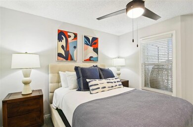 Bedroom with ceiling fan and a textured ceiling