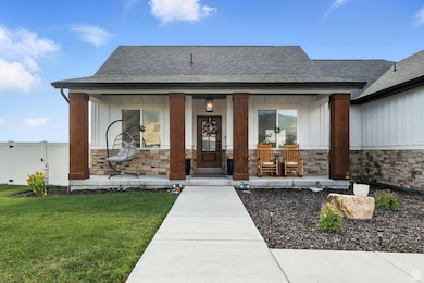 Entrance to property with covered porch, stone siding, roof with shingles, and board and batten siding