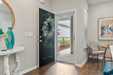 Foyer entrance with dark wood finished floors, hea