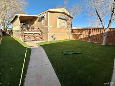 Back yard has faux grass and a large covered patio