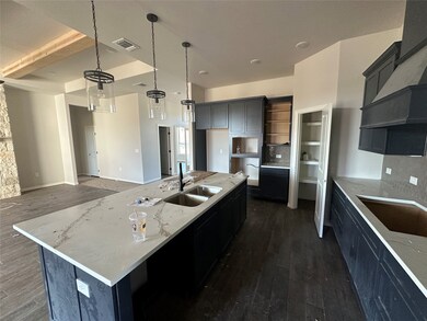 Kitchen featuring backsplash, dark cabinets, dark wood finished floors, and beamed ceiling