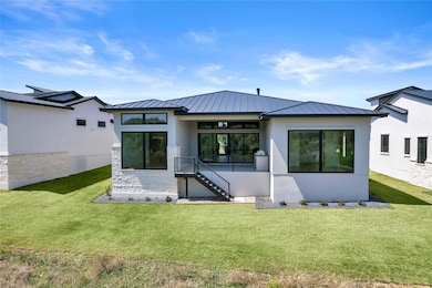 Rear view of house with stone siding, metal roof,