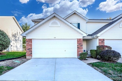 Traditional home with brick siding, driveway, and a garage