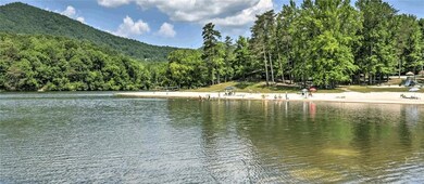 Water view featuring a wooded view and a mountain 