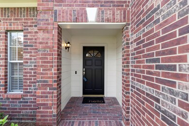Inviting, covered front porch with a crisp black door to contrast the light entry siding.