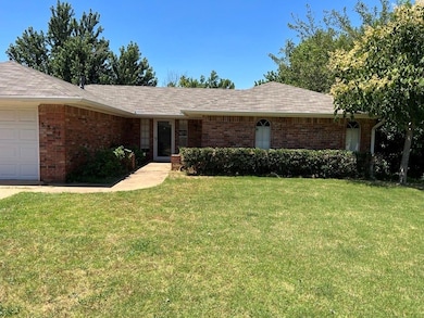 Ranch-style home with brick siding, a front yard, and a garage