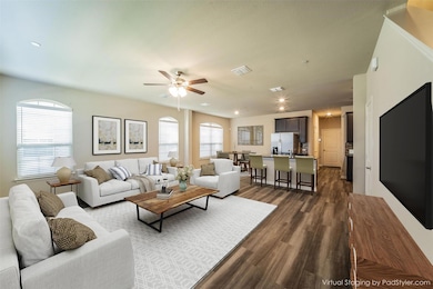 Large, elegant and open living, dining & kitchen - virtually staged to show potential! Luxury vinyl plank flooring. Staircase is to the right of this photo.