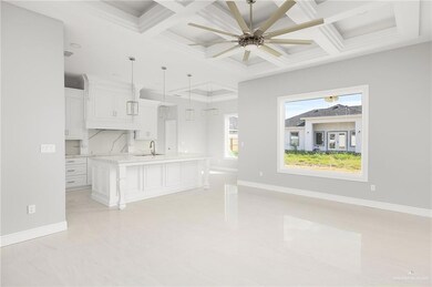 Kitchen with light countertops, a sink, a ceiling fan, and coffered ceiling