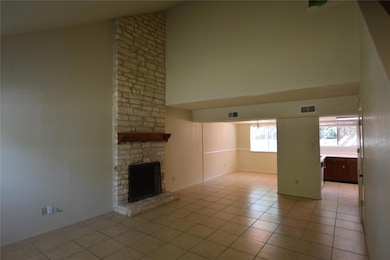 Unfurnished living room with high vaulted ceiling, a stone fireplace, and light tile patterned flooring