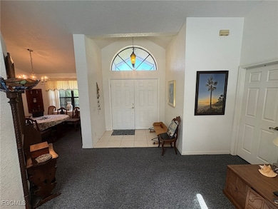 Tiled foyer entrance with carpet flooring, a chand