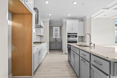 Kitchen featuring sink, wall chimney range hood, l