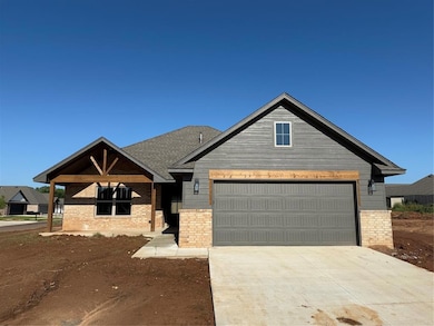 View of front of property with brick siding, driveway, and a garage