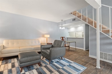 Living room with dark wood-style floors, a textured ceiling, and stairway