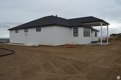 View of side of home featuring a patio and roof with shingles