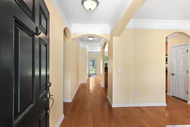 Entrance foyer with crown molding, arched walkways