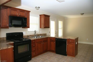 Kitchen with black appliances including a built-in microwave, slide in oven/range, dishwasher, and disposal.