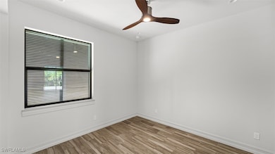 Empty room with ceiling fan and light hardwood / w