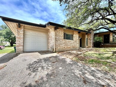 View of front of home with driveway, stone siding