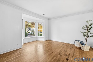 Spare room with ornamental molding and light wood-style floors