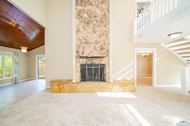 Unfurnished living room featuring high vaulted ceiling, carpet, a fireplace, baseboards, and tile patterned flooring