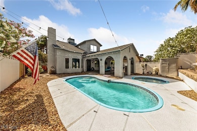 Rear view of house with a patio, an in-ground hot